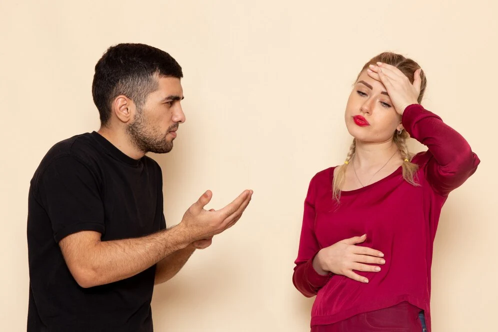 front view young female red shirt quarelling with young man cream space female cloth quarell confrontation 140725 28661